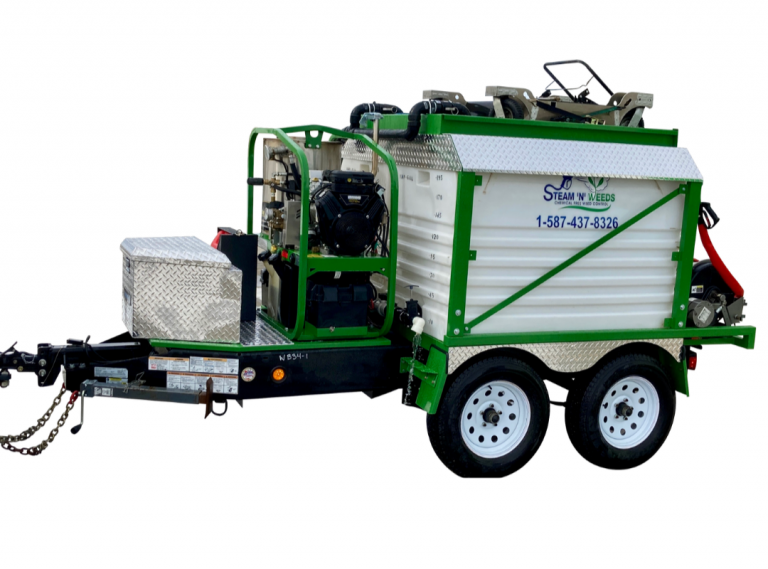 A green and white trailer with a large machine.